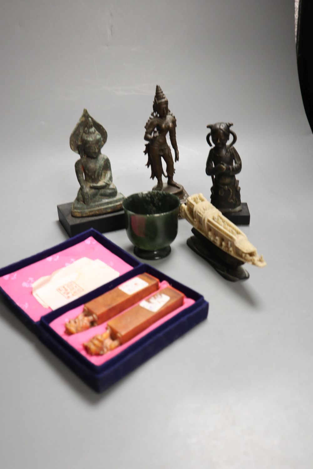 An Asian bronze Buddha, Ming bronze figure fragment and an Indian bronze figure, a hardstone cup, soapstone seals etc, tallest 15.5cm